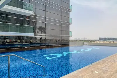 a swimming pool in front of a building at Frank Porter - Carson Tower C in Dubai
