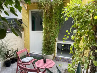 a red chair and a table in front of a door at Tropicana Guestroom 7 min walk from the beach in Dubai