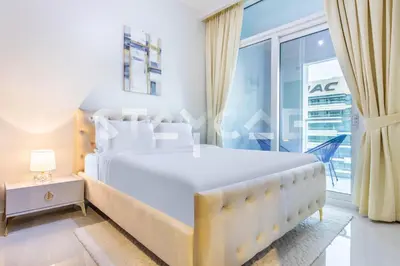 a white bedroom with a large bed and a window at Staycae Holiday Homes - Reva in Dubai