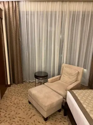 a hotel room with a bed and a chair and a table at Address Dubai Mall Fashion Avenue Full Burj Khalifa views Studio in Dubai