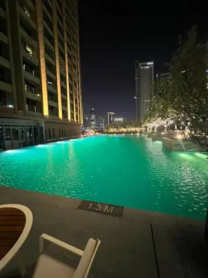 a large swimming pool at night in a city at Address Dubai Mall Fashion Avenue Full Burj Khalifa views Studio in Dubai