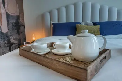 a tray with a tea pot and two cups on a bed at Luxury apartment 38th floor Dubai MarinaEXPO OFFER in Dubai
