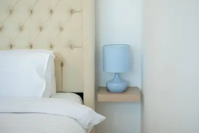 a blue lamp sitting on a night stand next to a bed at Classic Studio With Dubai Marina View in Dubai