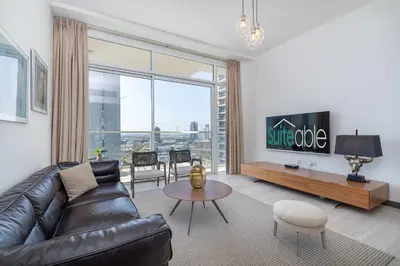 a living room with a leather couch and a table at Elegant 1br in Zaya Hameni in Dubai