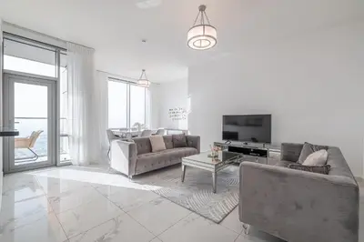 a living room with two couches and a tv at Noora Tower I Spacious 3BDR Apartment and maid room with Burj Khalifa View in Dubai
