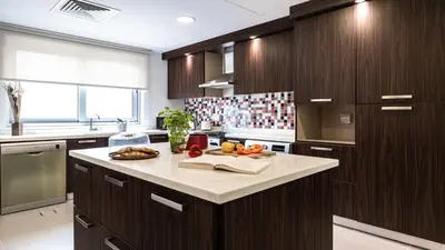 a kitchen with wooden cabinets and a white counter top at Hashtag Holiday Home - Luxury 2BDR Apartment on The Palm Azure Residences in Dubai