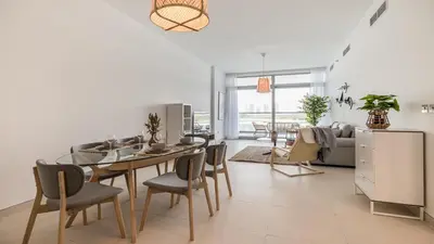 a living room with a table and chairs and a couch at Hashtag Holiday Home - Luxury 2BDR Apartment on The Palm Azure Residences in Dubai