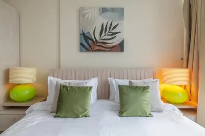 a bedroom with a bed with green pillows and two lamps at 2 Bedroom Apartment I Marina Diamond 4 I Close To Metro in Dubai