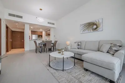 a living room with a couch and a table at Close To Metro with Frame View in Dubai