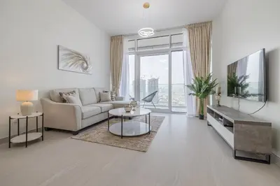 a living room with a couch and a table at Close To Metro with Frame View in Dubai