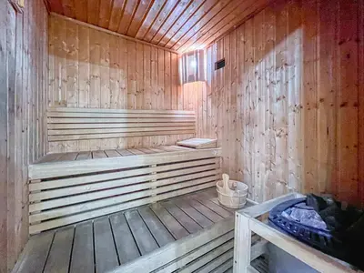 a wooden sauna with a bench and a bucket at Spacious 1BR with full Marina View in Dubai