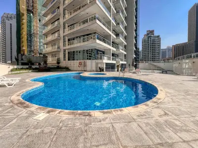 a large swimming pool in front of a building at Spacious 1BR with full Marina View in Dubai