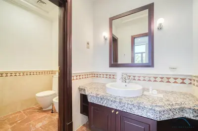 a bathroom with a sink and a mirror and a toilet at Signature 6BR Villa with Assistant Room and Private Pool in Frond F Palm Jumeirah by Deluxe Holiday Homes in Dubai