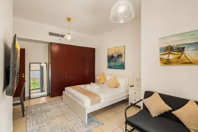 a bedroom with a bed and a couch in a room at Beautiful 2BR & 4BR Apartments on JBR Beach, Walking Distance to Bluewaters Island - By Sunkissed Holiday Homes in Dubai