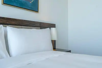 a bed with white sheets and pillows in a room at Exquisite Apartment Minutes Away from the Beach in Dubai