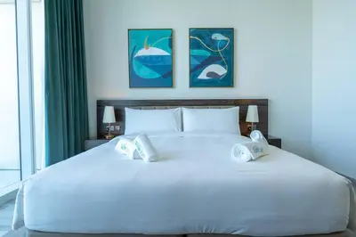 a bedroom with a large white bed with two pillows at Exquisite Apartment Minutes Away from the Beach in Dubai