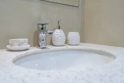a bathroom counter with a sink with two vases on it at Exquisite Apartment Minutes Away from the Beach in Dubai