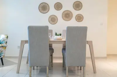 a dining room table with two chairs and plates on the wall at Charming Apartment in Central Dubai Marina in Dubai