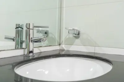 a white sink in a bathroom with a mirror at Charming Apartment in Central Dubai Marina in Dubai