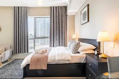 a bedroom with a bed and a large window at Waterfront Yachts View Studio in Bay Central, Dubai Marina in Dubai