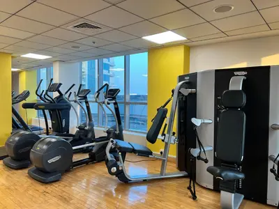 a gym with several treadmills and elliptical machines at Waterfront Yachts View Studio in Bay Central, Dubai Marina in Dubai