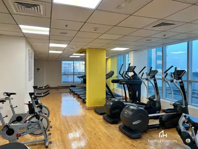 a gym with treadmills and elliptical machines at Waterfront Yachts View Studio in Bay Central, Dubai Marina in Dubai