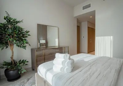 a bedroom with a large white bed with a mirror at Nasma Luxury Stays - Harbour Gate Tower 1 in Dubai