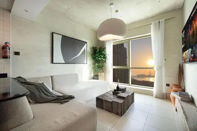 a living room with a couch and a large window at Lovely Dubai Eye & Sea View, 3 mints to beach in Dubai