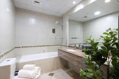 a bathroom with a tub and a toilet and a sink at Lovely Dubai Eye & Sea View, 3 mints to beach in Dubai
