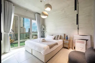 a bedroom with a bed and a large window at Lovely Dubai Eye & Sea View, 3 mints to beach in Dubai