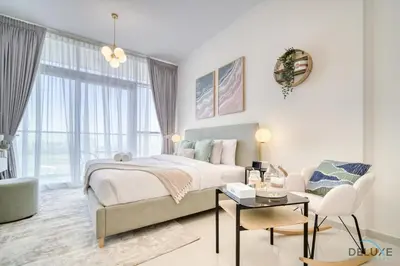 a bedroom with a bed and a living room at Calm Studio at Carson C DAMAC Hills Dubailand by Deluxe Holiday Homes in Dubai