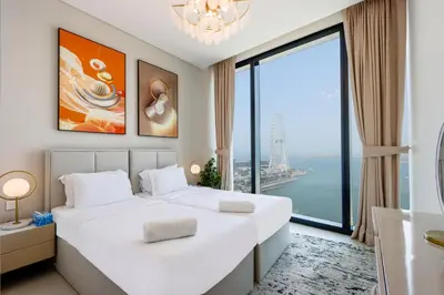 a bedroom with two beds and a large window at Livbnb - Lush 2BR Suite with Sea and Ain View in Address JBR in Dubai