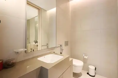 a white bathroom with a sink and a toilet at Livbnb - Lush 2BR Suite with Sea and Ain View in Address JBR in Dubai