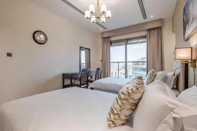 a bedroom with two beds and a desk and a window at Spacious 2BDR Apartment in Business Bay Habtoor City in Dubai