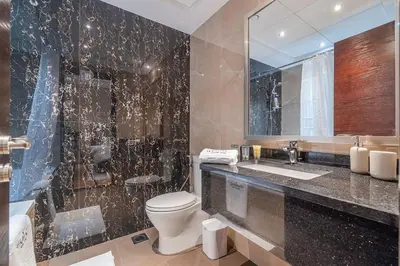 a bathroom with a toilet and a sink and a mirror at Spacious 2BDR Apartment in Business Bay Habtoor City in Dubai