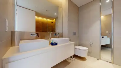a bathroom with two sinks and a toilet at Bluewaters Island 2 and 1 BDR Apart with Sea Views in Dubai