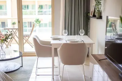 a dining room with a table and chairs with wine glasses at Central studio in The Greens 10min to MetroStation in Dubai