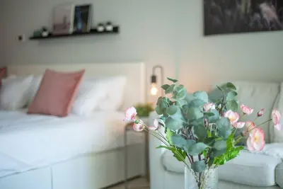a vase with flowers on a table in a living room at Central studio in The Greens 10min to MetroStation in Dubai