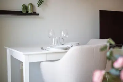 a white table and chairs with wine glasses on it at Central studio in The Greens 10min to MetroStation in Dubai