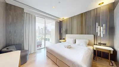 a bedroom with a large white bed and a window at FIVE Palm South -Opulent Two Bedroom with Sea View in Dubai
