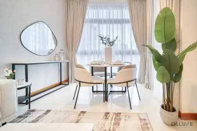 a dining room with a table and chairs and a plant at Hot Deal Modern 1BR at Iris Blue, Don't Miss Out by Deluxe Holiday Homes in Dubai