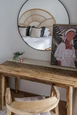 a mirror above a wooden table with a bed at GuestReady - Bohemian Apt with Marina View in Dubai