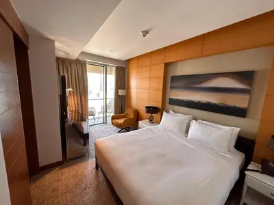 a hotel room with a large bed and a chair at Fashion avenue - Formerly Address Dubai Mall Residence in Dubai