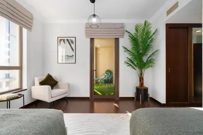 a bedroom with a couch and a chair and a plant at Ultimate Stay 2BR Sea View at JBR Beach Ain Dubai High Floor Luxury Stay in Dubai
