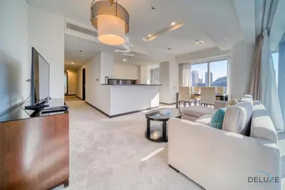 a living room with a couch and a tv and a kitchen at Overlooking Marina Canal Views from Living to Bedroom, The Address Residences, Dubai Marina by Deluxe Holiday Homes in Dubai