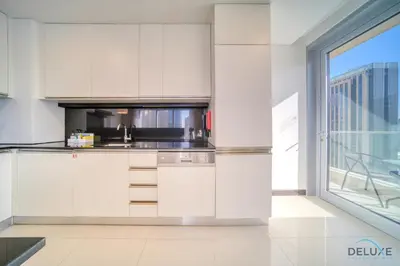 a kitchen with white cabinets and a large window at Overlooking Marina Canal Views from Living to Bedroom, The Address Residences, Dubai Marina by Deluxe Holiday Homes in Dubai