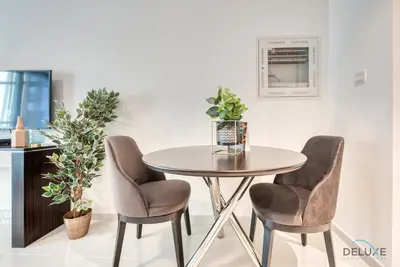 a dining room table with two chairs and a table at Luxuriant Studio at Golf Promenade 2A DAMAC Hills by Deluxe Holiday Homes in Dubai