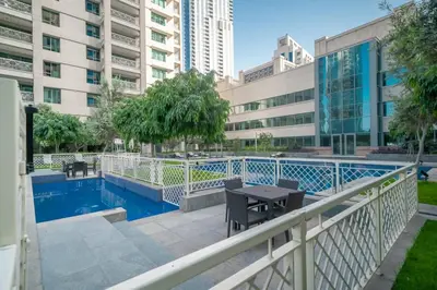 a balcony with a table and a swimming pool at BellaVista - Exuberant - 1BR - 29 Boulevard - Fountain Views in Dubai