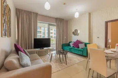 a living room with a green couch and a table at BellaVista - Exuberant - 1BR - 29 Boulevard - Fountain Views in Dubai