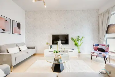 a living room with a couch and a table at Vogue 2BR at Shams 2 JBR by Deluxe Holiday Homes in Dubai
